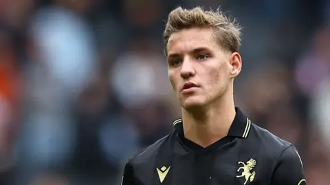Sam Gale looks on wearing a black Gillingham kit