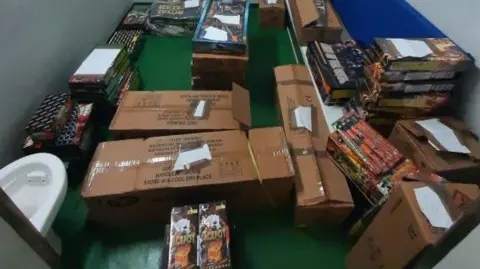 Fireworks found in a house in Seacroft, shown stored in cardboard boxes in a room.