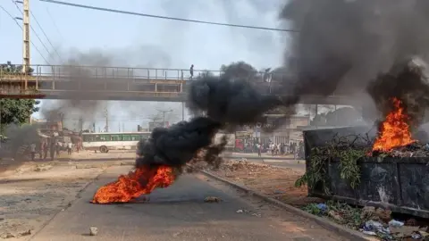 Fire and smoke on a street in Mozambique's capital Maputo, after police dispersed protesters