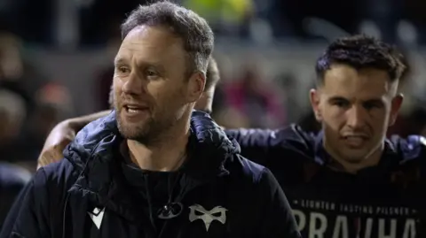 Ospreys head coach Mark Jones talks to his players