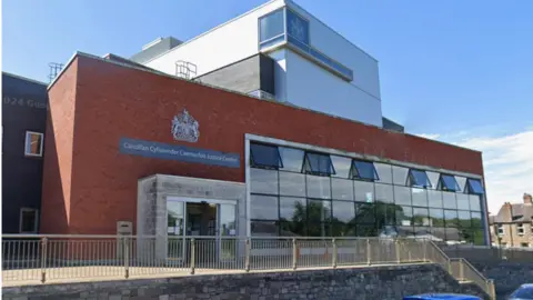 Caernarfon Crown Court exterior, a red brick building with a big wall of windows