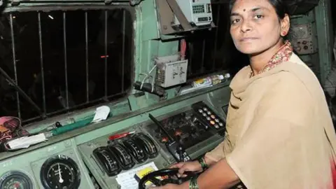 Central Railway/Twitter an old image of Surekha Yadav in an Indian beige dress in the train control room.