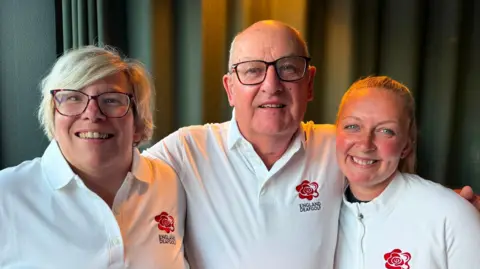 Charlotte Dixon, Brian Robinson and Donna Serridge-Cross are all wearing white polo shirts with a red rose on them with the words England Deaf Golf written below the rose