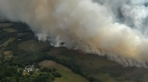 Dorset and Wiltshire Fire and Rescue Service Aerial shot of fields obscured by smoke with an orange trail of fire.