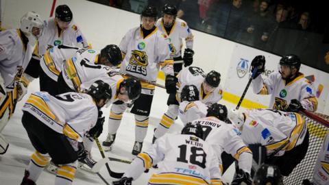 Berkshire Bees players gathering near an ice hockey goal