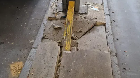 Bedford Borough Council An image showing cracked concrete slabs at a car park and a yellow part of an entry post protruding out of them