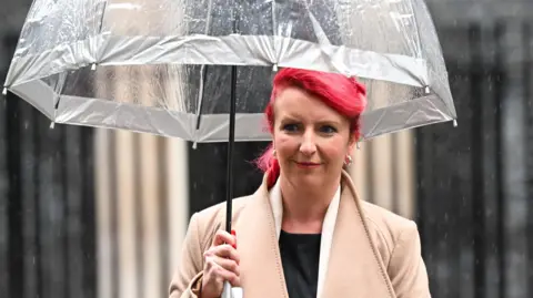 Getty Images Louise Haigh, pictured in Downing Street holding an umbrella and sporting high-dyed hair