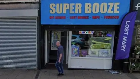 Super Booze in Hillsborough, a shop with a yellow sign on a blue background.