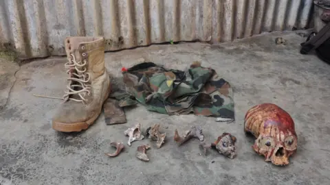 Noeline Nabukenya An image of military attire, small bones fragments and a bloody skull.