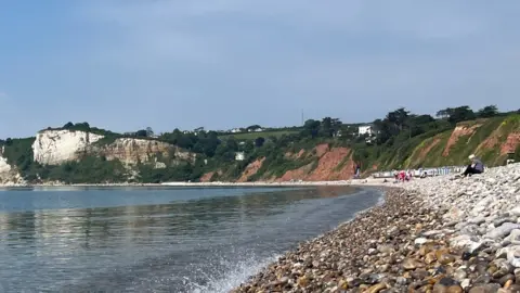 The beach and the coastline from Seaton beach looking towards Beer and showing the site of a serious landslip at Seaton Hole