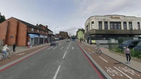 Sheffield City Council An artists impression of a modern high street showing a wide two lane road with red cycle lanes on either side and pedestrians walking along the pavement.
