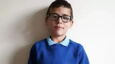 Family Alfie Steele in his blue school uniform and glasses before his death