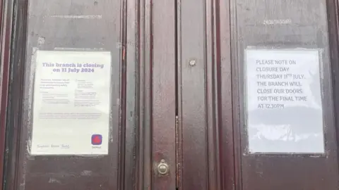 BBC/Daniel Sexton Two signs on the door of NatWest outlining the July 11th closure