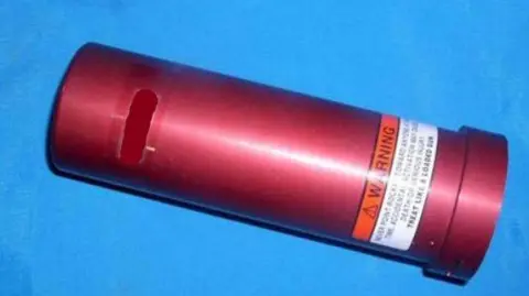 Greater Manchester Police A red tube on a blue background - part of the parachute system which contains propellant.