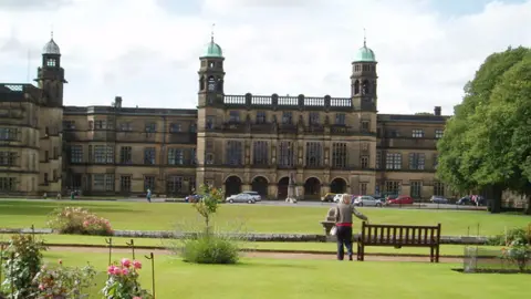 Mark Belshaw / Wikicommons Image shows the lawns and front facade of Stonyhurst College near Clitheroe. It is a 16th Century four-storey building with three clock verdigris towers on display. 
