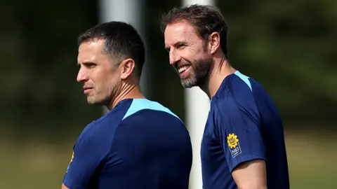 Steve Kemp on the left and Gareth Southgate on the right. They are on a training pitch and wearing blue football shirts