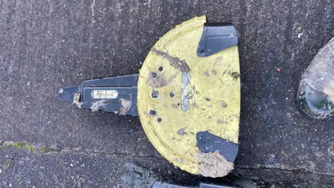 Yorkshire Water A steering wheel lock, laid on the ground. It is yellow and black. It is dirty, having been recovered from a sewer.