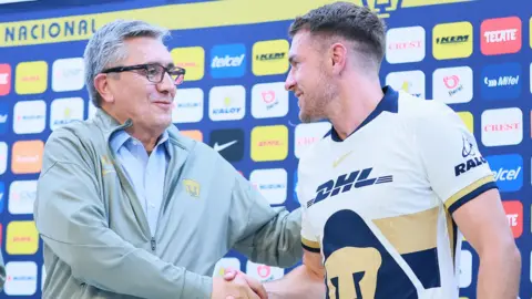 Aaron Ramsey shakes hands with president of Pumas, Luis Raul Gonzalez Perez during his unveiling as a new player at the club.