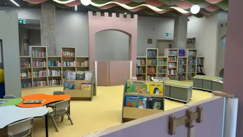 Aimee Dexter/BBC A children's area of a library which is castle themed. There are short bookshelves and small tables and chairs dotted about. 