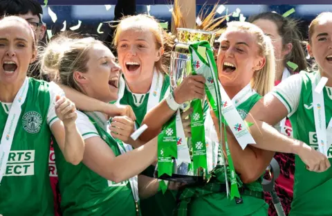 Hibernian’s Rachael Boyle and Siobhan Hunter lift the SWPL trophy at Ibrox