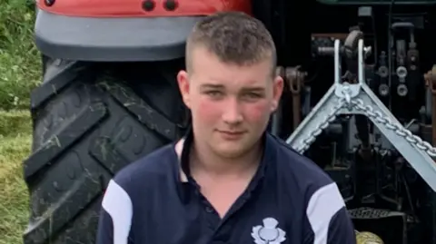 PSNI Isaac Roxborough sitting in front of a tractor