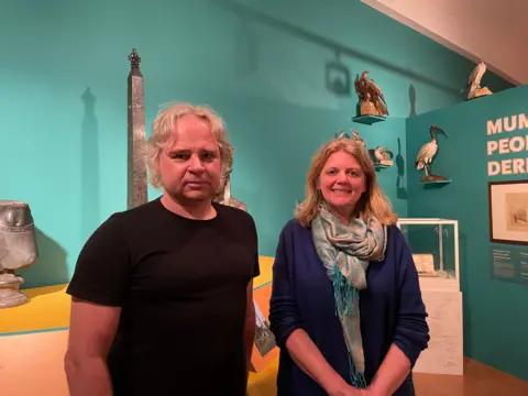 Man and woman standing in Egyptian exhibition inside Derby Museum