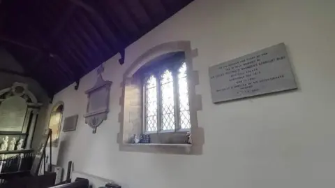 St Leonard's Church The picture shows a led panelled window in St Leonards church and the empty space underneath another memorial, where the coat of arms and memorial once hung. 