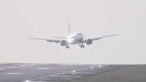 A white plane landing on the runaway at Leeds Bradford Airport