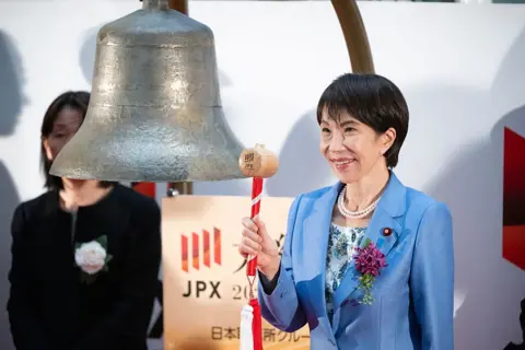 Getty Images Sanae Takaichi, Japan's prime minister, prepares to strike a bell during a ceremony marking the last trading day of the year at the Tokyo Stock Exchange (TSE) in Tokyo, Japan