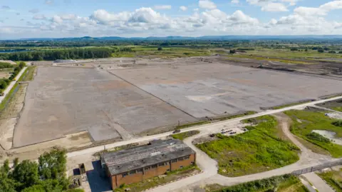 Agratas aerial photo of a brownfield site of flat land with green vegetation around the perimeter