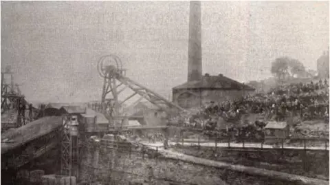 Supplied An old image of a colliery. Crowds of people can be seen sat on a hill, overlooking the mine.