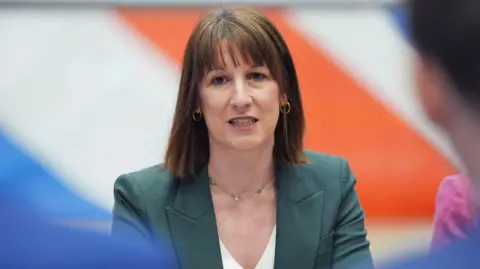 Getty Images Chancellor Rachel Reeves wearing a green jacket and white blouse with gold and green necklace