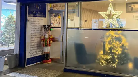 A nutcracker statue stands on the porch of a funeral home. 