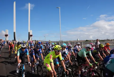 PA Media Cyclists in the Tour of Britain riding over the Gull Wing Bridge