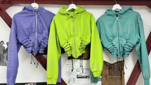 Timothy Gibbons Three hoodies, one purple, one green and one blue