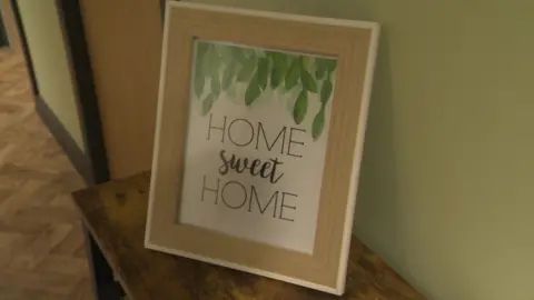 A sign saying home sweet home in a picture frame.