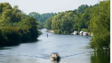 Andrew Matthews/PA Wire A boat being driven along the River Thames on a sunny day 