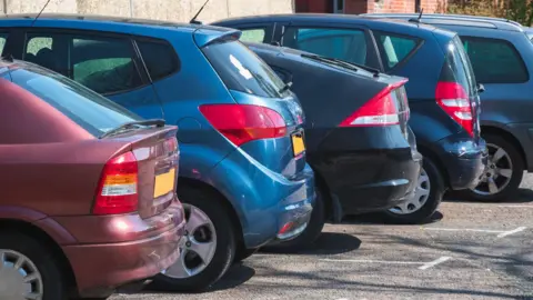 Getty Images The boot-side of five parked cars 