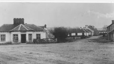 Heritage Service, Dumfries and Galloway Council An old image of houses in Crocketford around a rough-looking road surface