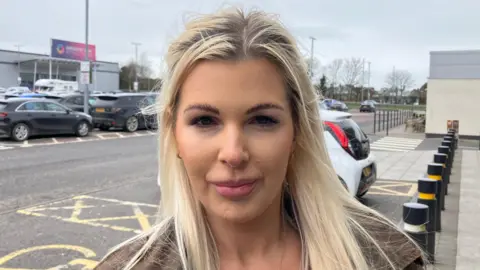 A woman with blonde hair looking at the camera