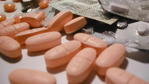 A generic image of pink pills on a counter, with some in blister packs.