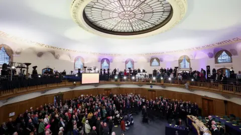 A wide shot of people attending the Synod