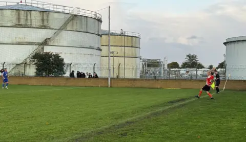 Paul Gully A throw in taken from the side of the pitch with the petrol towers in the background