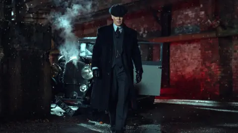 Courtesy of Netflix A still of the upcoming Peaky Blinders movie shows Cillian Murphy as Thomas Shelby walking away from a crashed car.