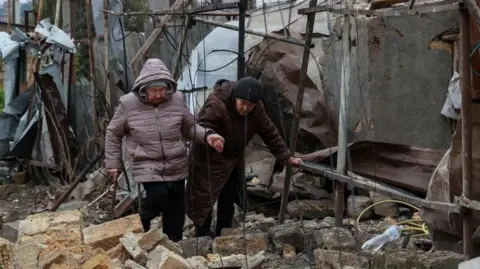 Reuters elderly women pick their way through rubble in Odesa