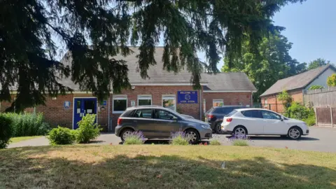 Cars and tree in front of a school building