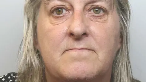 Cheshire Police A woman with grey blonde hair stares at the camera in a police mugshot