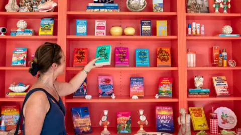 A customer looks at romance novels books in a west London bookshop