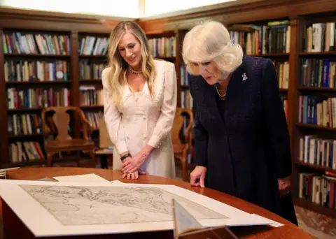 Pool via Reuters Sarah Jessica Parker and Queen Camilla study a large etching against the background of bookshelves, at the New York Public Library on Wednesday.