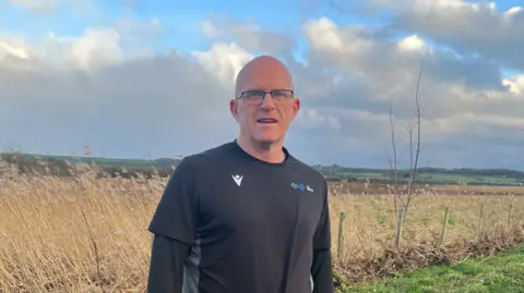 A man wearing a black t-shirt